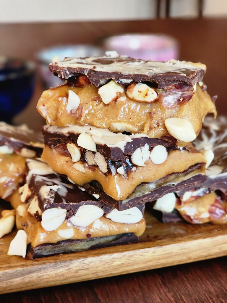 a stack of chocolate covered gooey peanut butter taffy with peanuts inside